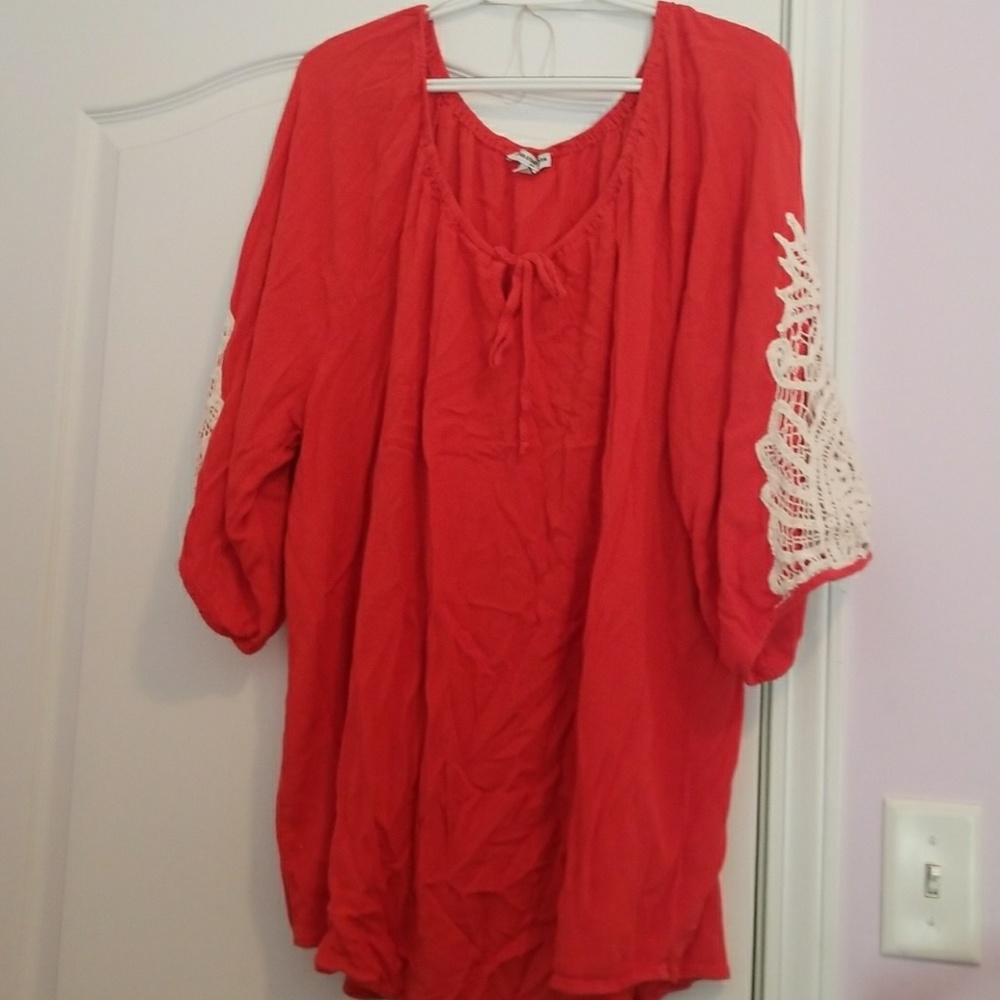 Orange top with crochet degin on arm